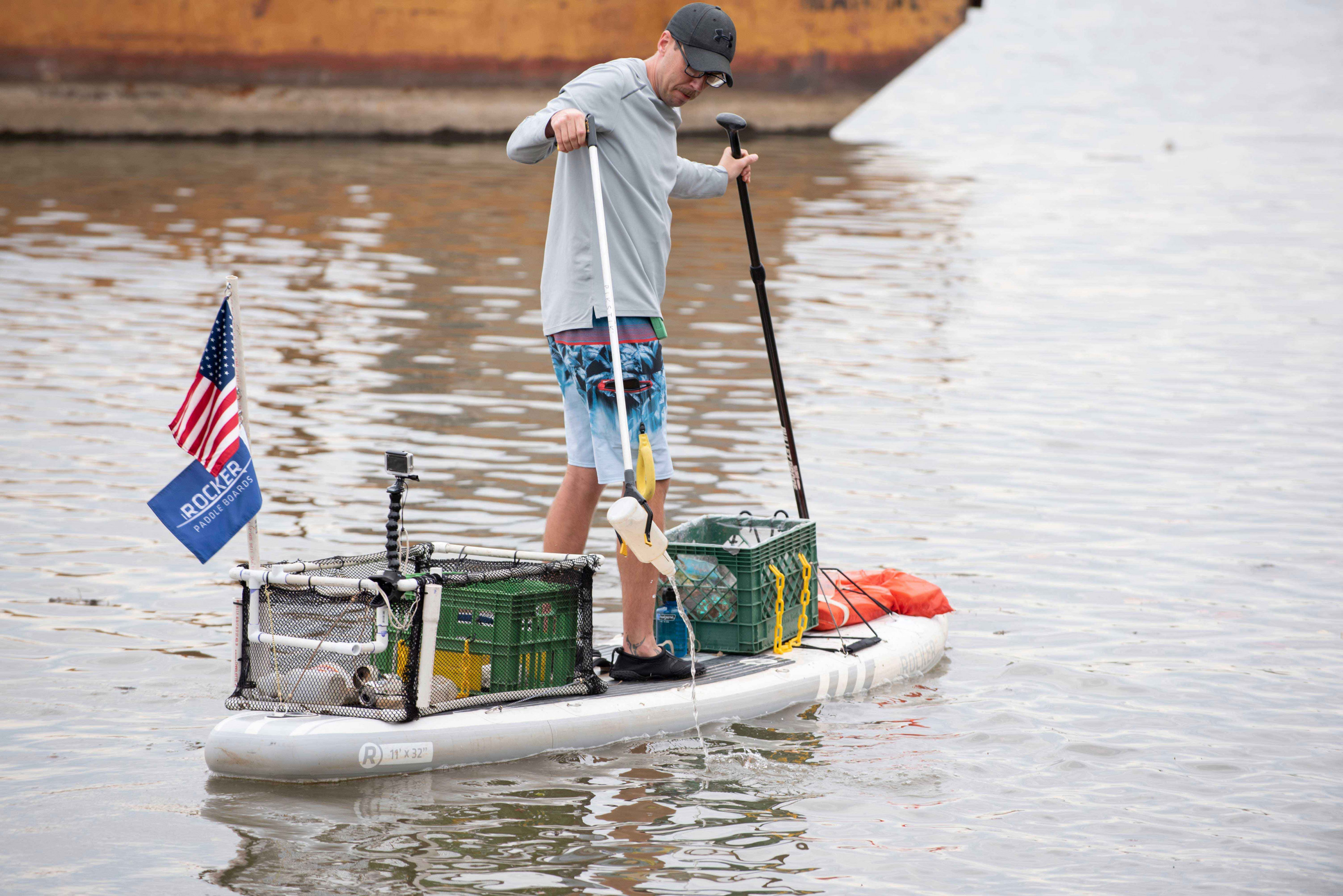 Joseph Wright picks a bottle out of the Potomac River on October 25, 2019 in Alexandria, VA.