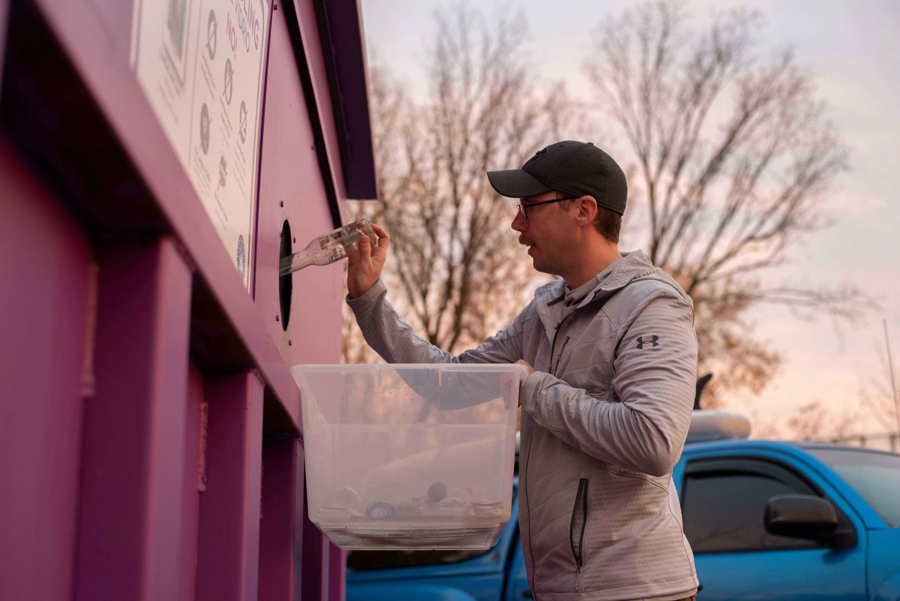 Following a SUPing session, Joseph Wright disposes of a beer bottle into the glass recyclables dumpster on November 15, 2019 in Alexandria, VA. When removing litter from the water, Wright separates the different types of plastics based on Fairfax County&#039;s recycling codes.