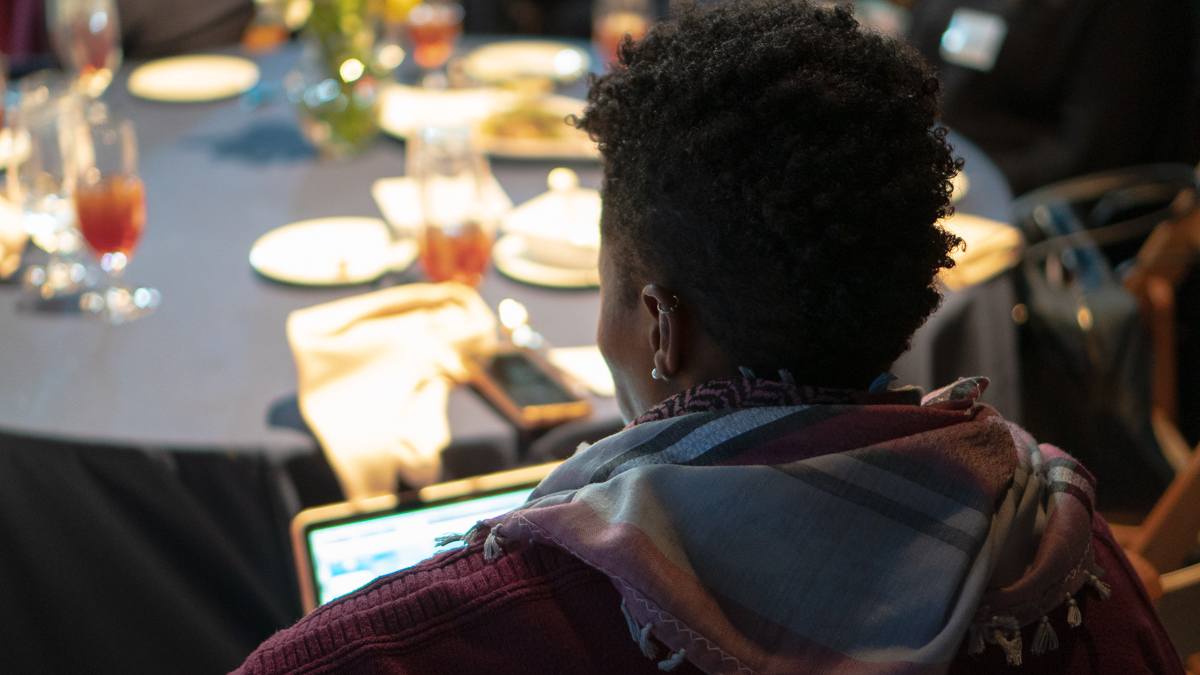School of Media and Public Affairs Assistant Professor Dr. Imani Cheers takes notes during the conversation.