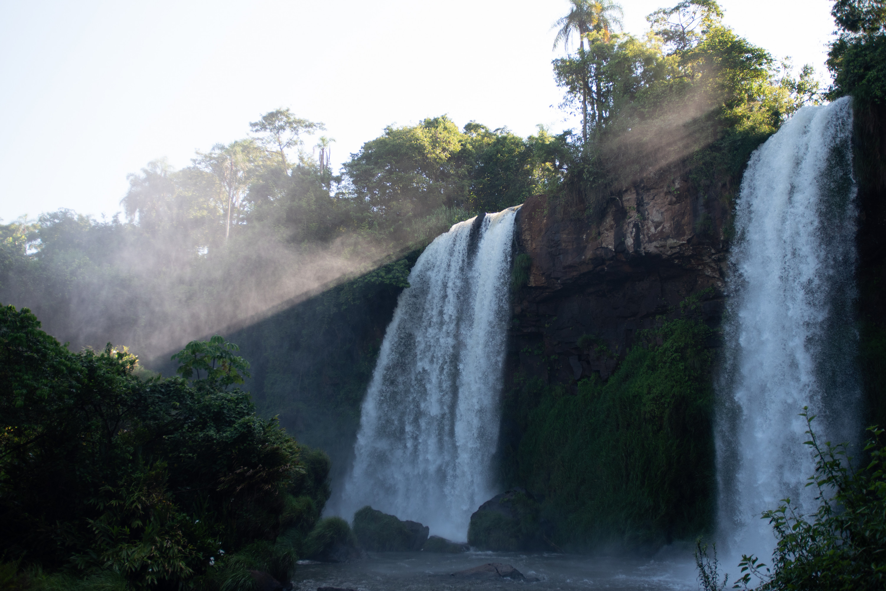 The light from the sun breaks through the mist of a waterfall in Iguazú National Park.
