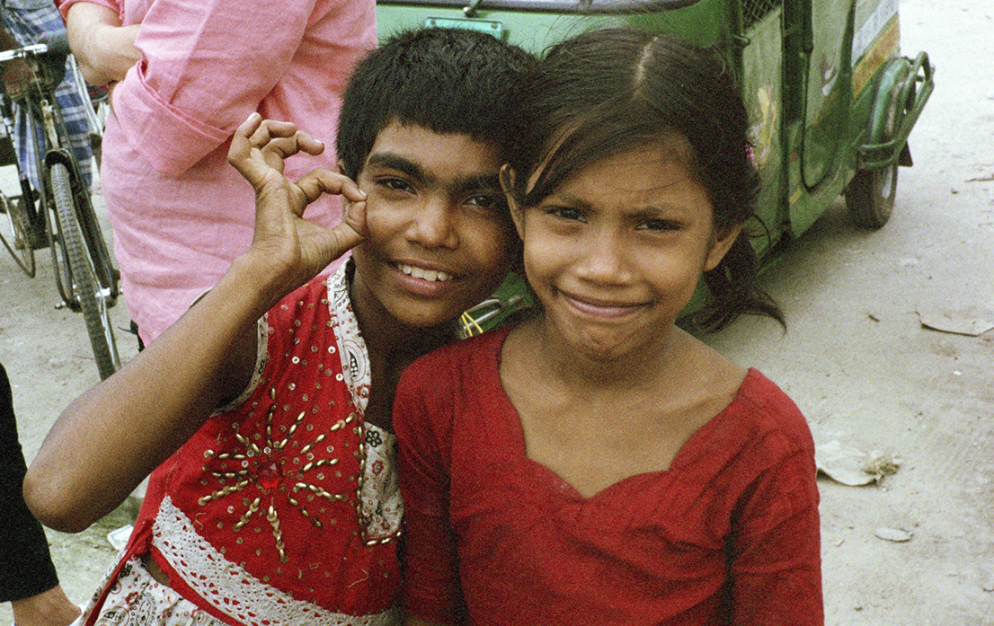 Two young girls on their way home from the market with fruits for their sick uncle.