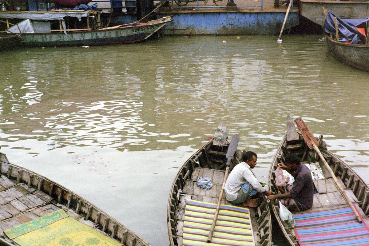 Two boaters converse along the river.