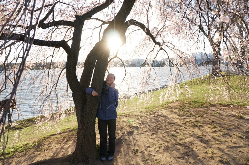 Kenzie Schmitt with a cherry blossom tree. (Wes White)