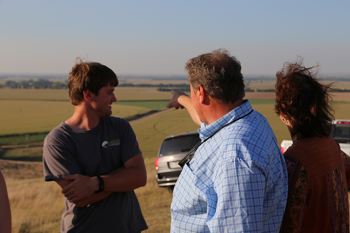 The McPheeters family points out landmarks on their farmland from a hilltop on their land. (Planet Forward staff)