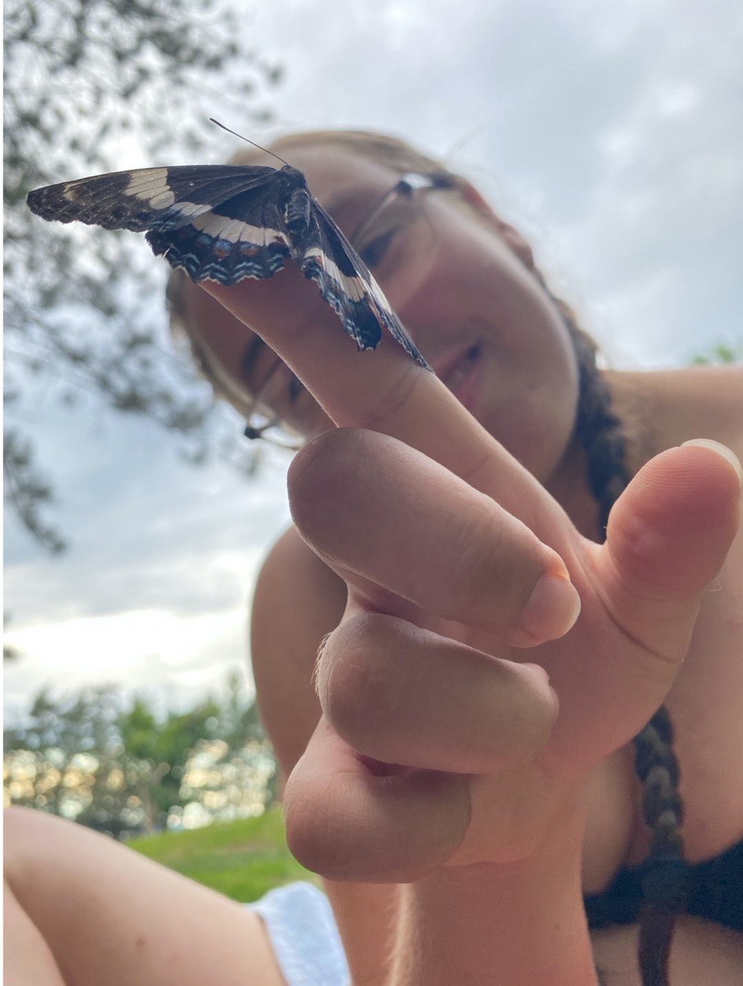 A student curiously gazing at a moth found in the grass.