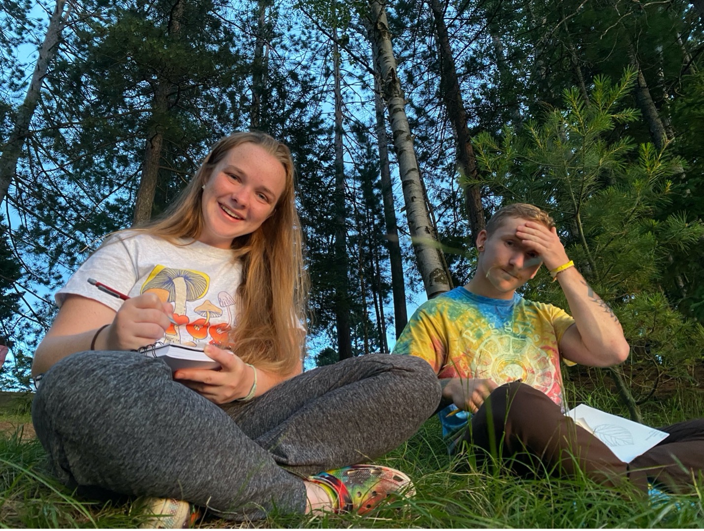 Students in the forest journaling about the nature that surrounds them.
