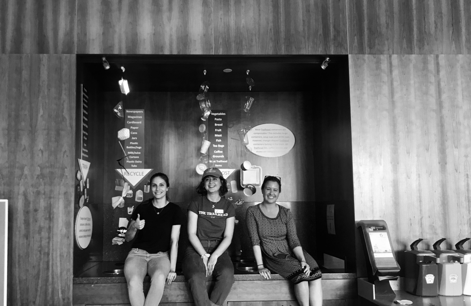 Sue Fassler, Devon Camillieri, and sustainability advocate Amelia Hoffman sit on top of the compost bins. (Image courtesy Devon Camillieri)