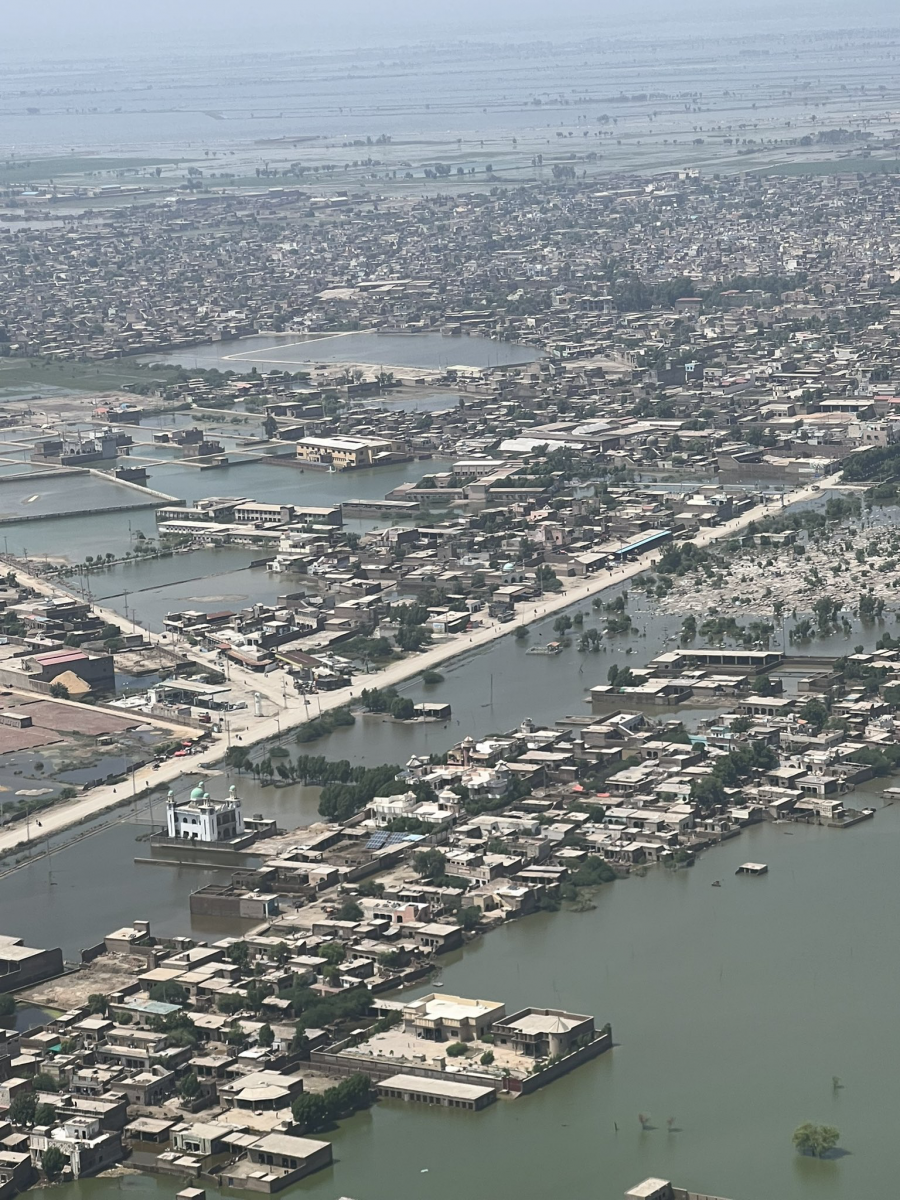 An aerial view of a city in Pakistan where in much of the land area excepts for the roofs of buildings is covered by flood water.