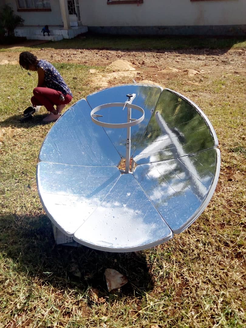 A prototype for a solar powered water filer. A reflective metallic dish point to the sky with a skinny column and attached hoop sticking out of the center of the dish. 