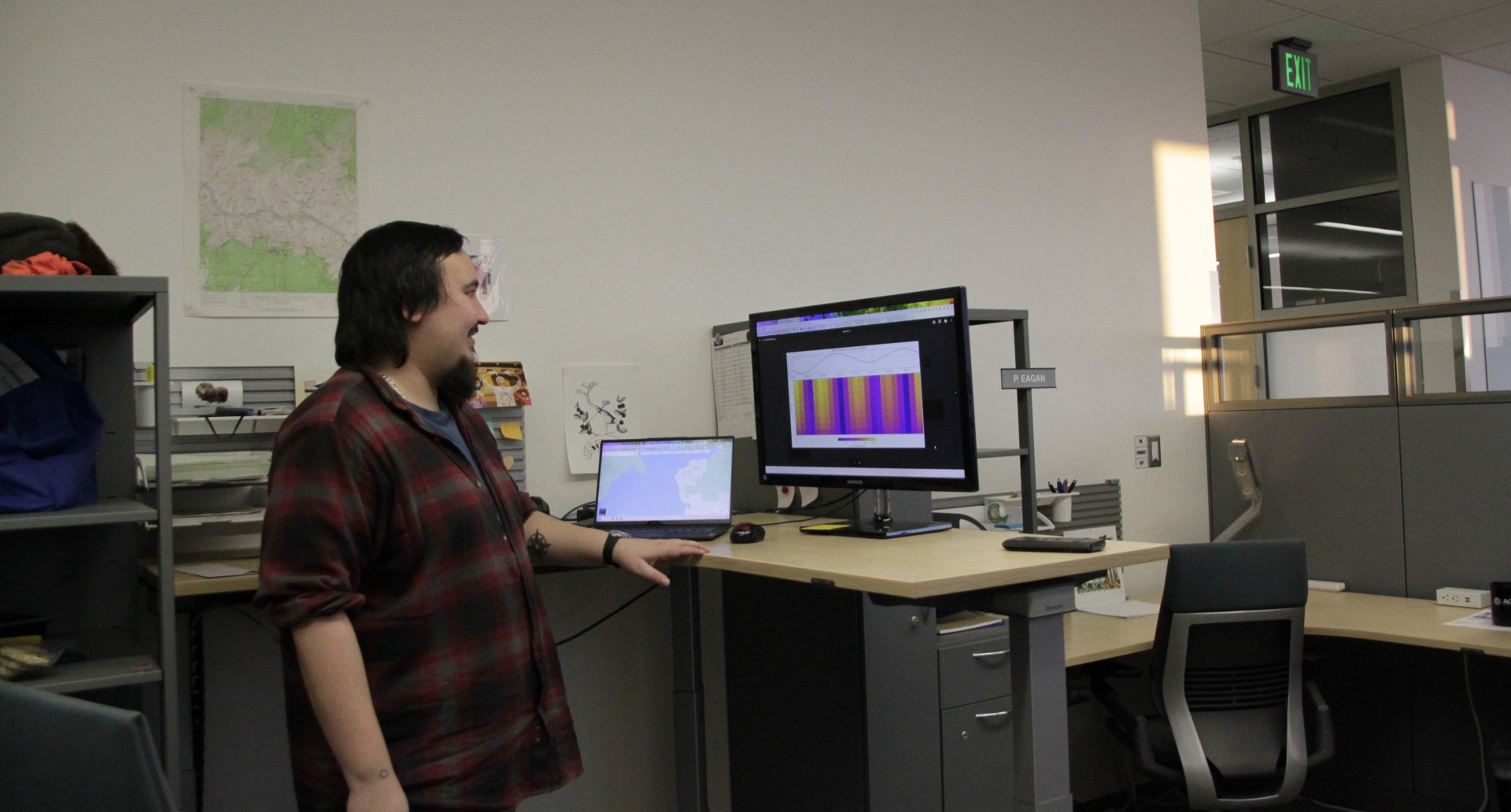 Bond looks at a computer screen with energy wavelengths illustrated on a graph.