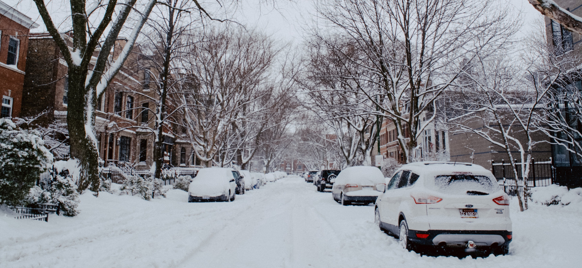 A residential street in Chicago covered in a sheet of white snow.
