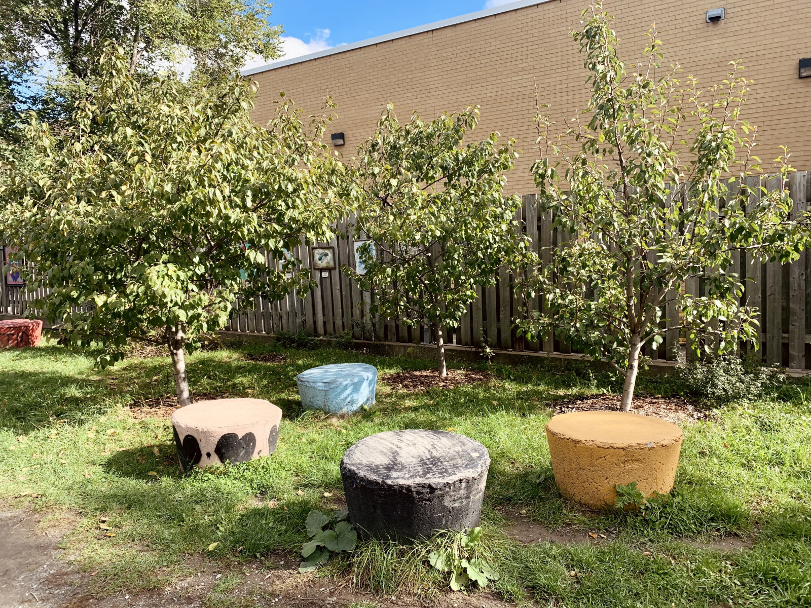 Several circular, painted outdoor seats in a grassy space.