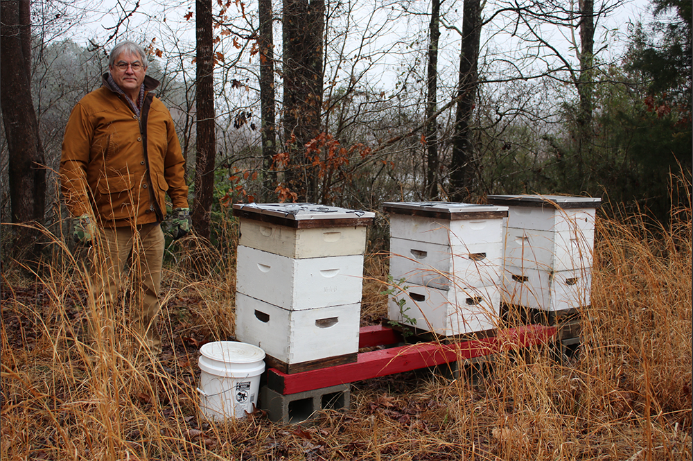 Ban stands next to constructed beehive.