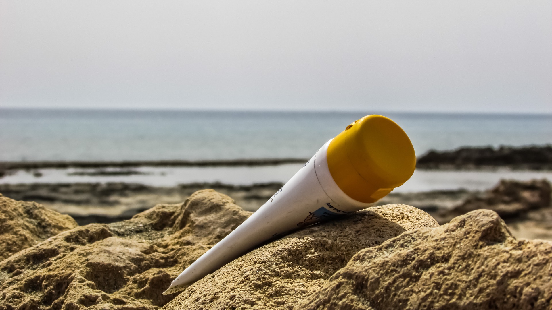 plastic suncream on beach