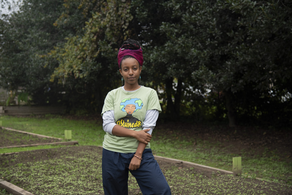A woman looks at the camera in a garden.