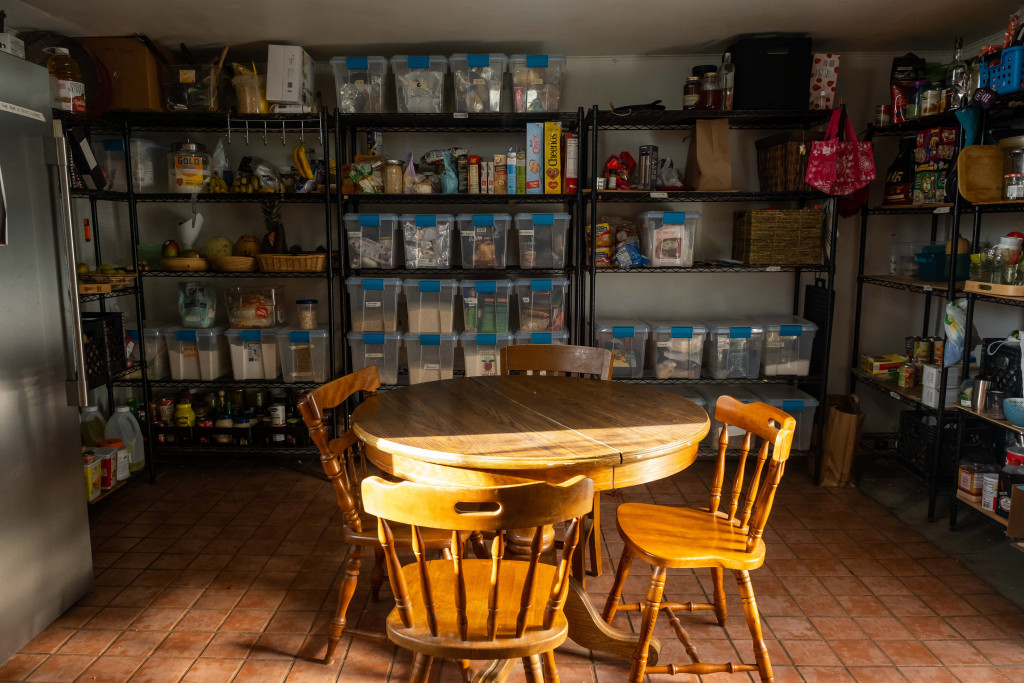 A small room with large containers of food on shelves.